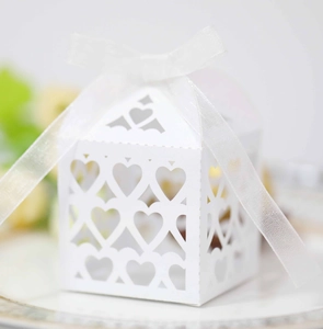 Close-up of laser-cut heart pattern on white candy box with elegant organza ribbon bow