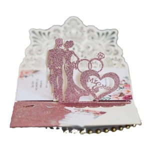 Faire-part de mariage 3D avec papier rose pailleté et silhouette découpée au laser de mariés