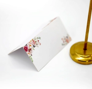 Elegant white laser-cut wedding place card with pink floral rose prints and gold stand
