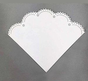Close-up of laser-cut lace paper with intricate floral hollow patterns on dark background