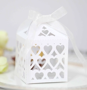 Detailed view of white heart-shaped laser cut wedding gift box with ribbon