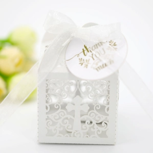 Detail of white laser-cut wedding gift box with cross pattern, ribbon and thank you tag