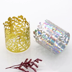 Detail of laser-cut floral napkin rings in gold and holographic finish with rose patterns