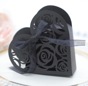 Macro detail of laser-cut rose patterns on elegant black heart-shaped wedding gift box