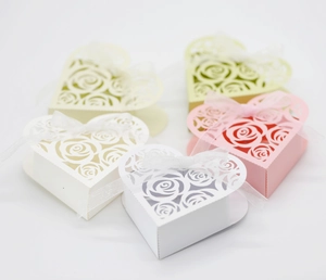 Macro shot of heart-shaped hollow rose candy boxes with assorted color paper and silk ribbons