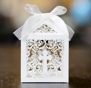 Detailed laser cut white wedding candy box with cross pattern and silk ribbon bow