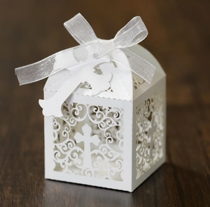 White laser cut wedding favor box with hollow cross patterns and white ribbon bow