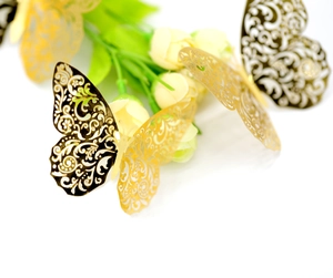 Close-up of golden 3D paper butterflies with intricate laser-cut floral patterns