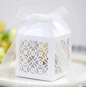 Close-up of white laser-cut floral paper gift box with elegant chiffon ribbon bow