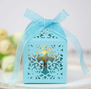 Elegant light blue laser-cut paper wedding favor box with floral patterns and silk ribbon