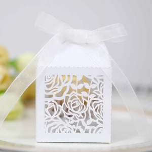 Elegant white laser-cut wedding favor box with rose patterns and ribbon decoration