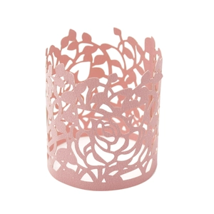 Detail of pink laser-cut paper napkin ring with intricate rose and leaf hollow patterns