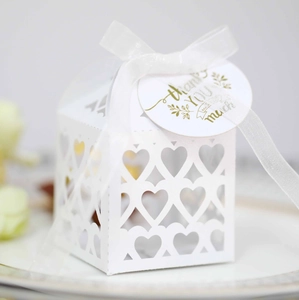 Detail of white heart-shaped hollow gift box with satin ribbon and thank you tag