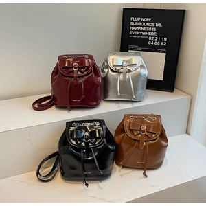 Mini high-gloss leather backpacks in burgundy, silver, black, and brown with metal chains