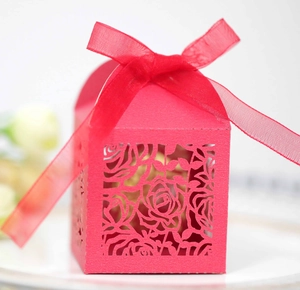 Romantic red laser-cut wedding favor box with rose patterns and matching organza ribbon