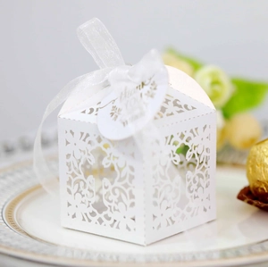 Detail of laser cut white wedding candy box with thank you tag and chiffon ribbon
