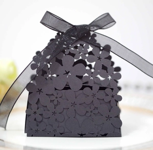 Detailed laser-cut floral pattern on black wedding favor box with organza ribbon