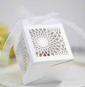 Close-up of white laser-cut floral candy box with elegant organza ribbon bow