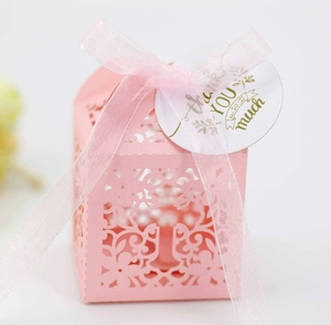 Pink laser-cut wedding favor box with cross pattern, pink ribbon and thank you tag