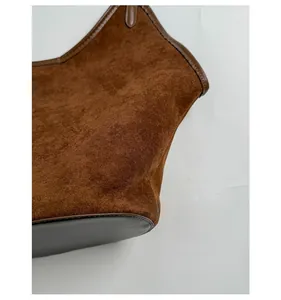 Close-up of brown suede tote bag showing soft texture and smooth leather edge