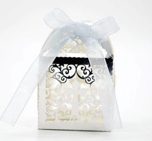Elegant laser cut white favor box with cross pattern and light blue organza ribbon