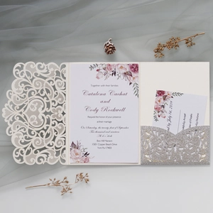 Detail view of laser-cut wedding invitation with glitter pocket and floral RSVP card