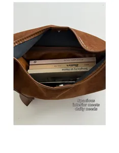 Vertical top view of brown faux suede tote bag showing large interior space and books