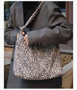 Détail du sac cabas en toile à motif léopard avec bandoulière nouée sur un mannequin
