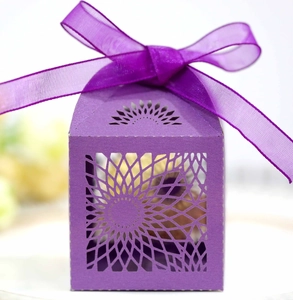 Close-up of purple hollow-out gift box with floral patterns and a matching organza ribbon