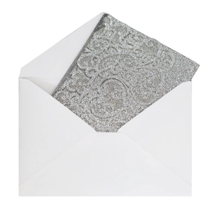 Close-up of silver glitter wedding invitation card with ornate embossed scroll texture