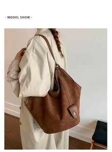 Detail view of a large brown suede tote bag featuring a soft slouchy design and slim straps