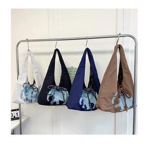 Detail of printed large canvas tote bags with elephant motif and plaid bow accents