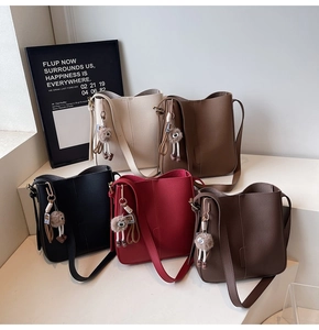 Close-up of pebble leather bucket bags in five colors with cute doll charms and straps