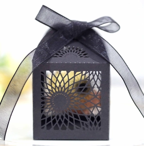 Close-up of laser-cut black hollow candy box with elegant organza ribbon tie