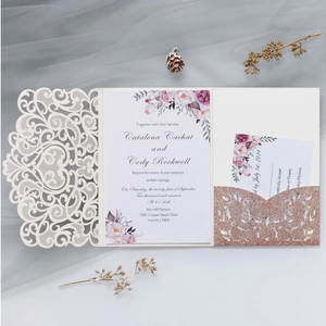 Detail of laser cut wedding invitation with rose gold glitter pocket and floral cards