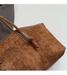 Nahaufnahme braune Wildleder-Tragetasche mit Lederpaspeln und Knotendetails