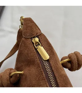 Dettaglio della cerniera in metallo dorato e della texture della pelle della borsa