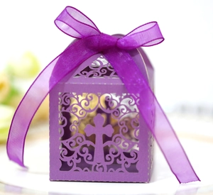 Macro detail of purple laser-cut candy box featuring ornate cross and satin ribbon