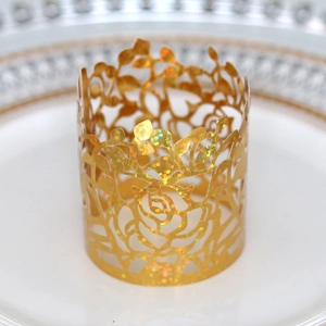 Close-up of laser-cut gold paper napkin ring with elegant rose flower pattern