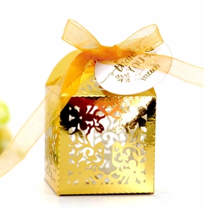Golden laser-cut hollow gift box with orange ribbon and thank you tag for weddings