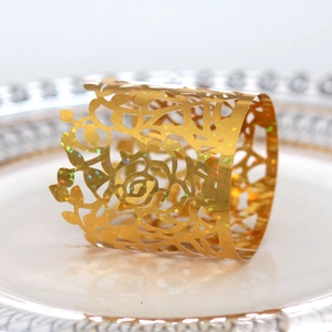 Macro detail of golden holographic glitter rose laser-cut napkin ring on white plate