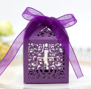 Detail of purple laser-cut wedding candy box with cross motif and ribbon bow