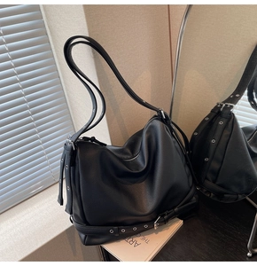 Close-up of litchi grain leather texture and silver eyelet buckle on the black hobo bag