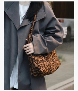 Détail du sac cabas léopard avec bandoulière nouée sur l'épaule du mannequin