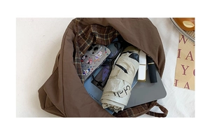 Interior view of large brown tote bag showing Scottish plaid lining and spacious storage
