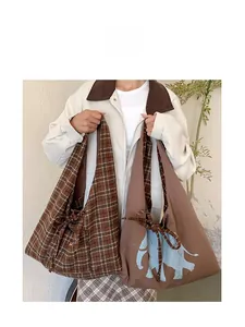 Detail of large canvas tote bags in classic brown plaid and artistic blue elephant print