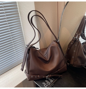 Close-up of deep brown pebble leather tote bag with silver eyelets and buckle details