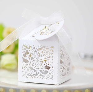 Detailed laser-cut white wedding favor box with ribbon and gold Thank You tag
