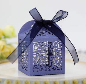Detail of laser-cut cross pattern on purple wedding favor box with blue ribbon bow