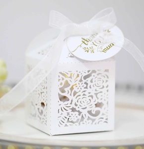 Close-up of white laser-cut hollow gift box with floral patterns and a Thank You tag